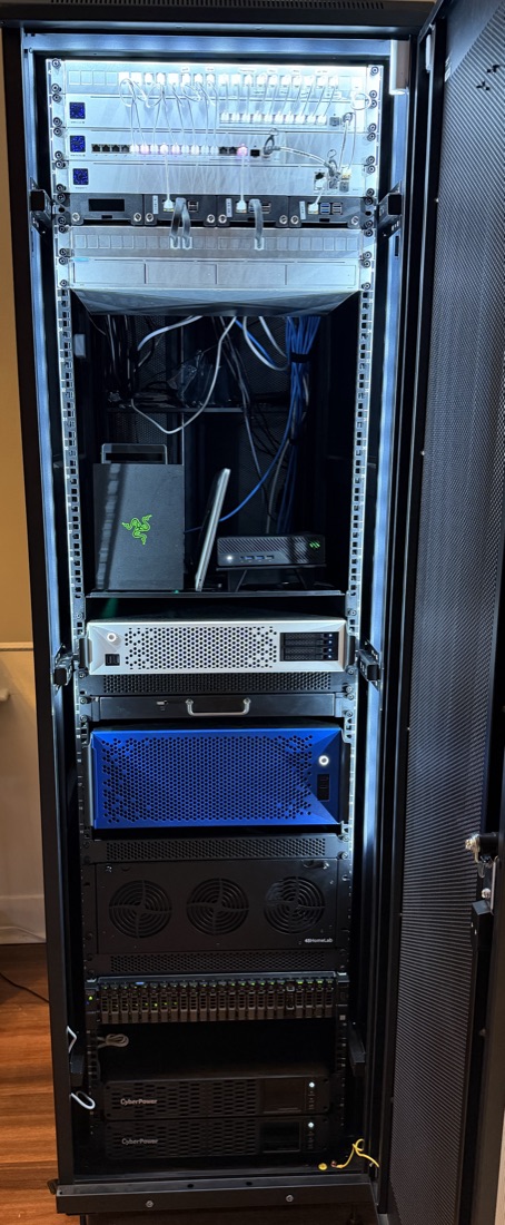 A 42U server rack with network switches, a patch panel, a Raspberry Pi shelf, several servers, a 15-bay storage server and two UPS units
